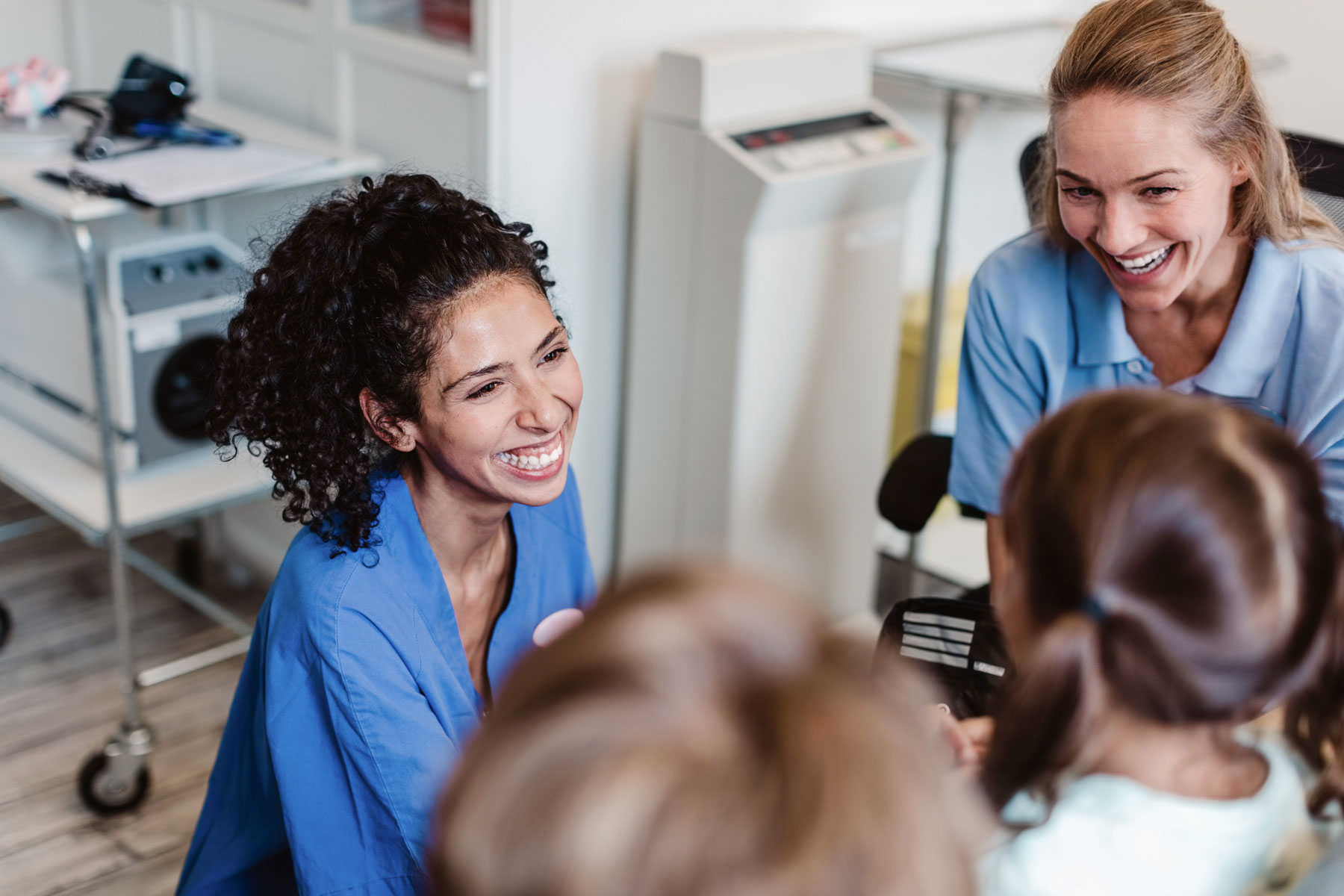 Två kvinnliga läkare pratar och skrattar med en patient
